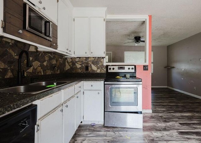 4709 Mcdonald Ave, West Columbia, SC 29172 - kitchen featuring stainless steel appliances, a sink, ceiling fan, white cabinets, and dark countertops