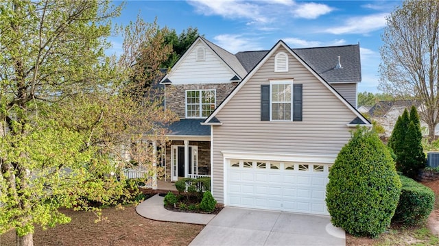 606 Greening Dr, Simpsonville, SC 29681 - traditional-style house with covered porch, concrete driveway, roof with shingles, an attached garage, and stone siding