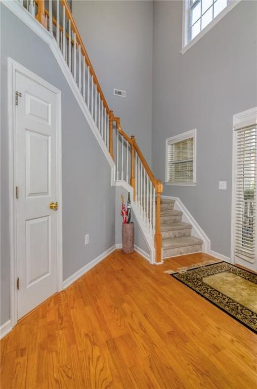 606 Greening Dr, Simpsonville, SC 29681 - foyer with a high ceiling, stairway, light wood-style floors, and baseboards