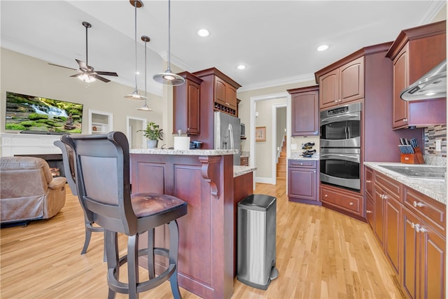 117 W Waters Edge Ln, West Union, SC 29696 - kitchen featuring stainless steel appliances, open floor plan, a breakfast bar area, light wood finished floors, and crown molding