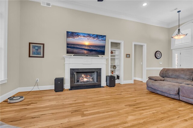 117 W Waters Edge Ln, West Union, SC 29696 - living room with built in features, baseboards, ornamental molding, light wood-type flooring, and a fireplace with flush hearth