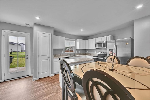 145 Queens Mill Ct, Pendleton, SC 29670 - kitchen with appliances with stainless steel finishes, a sink, white cabinets, light wood-style floors, and recessed lighting
