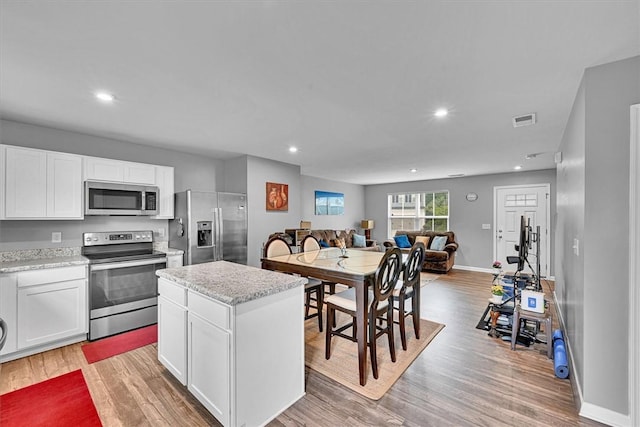 145 Queens Mill Ct, Pendleton, SC 29670 - kitchen with stainless steel appliances, open floor plan, light wood-style flooring, white cabinetry, and a center island