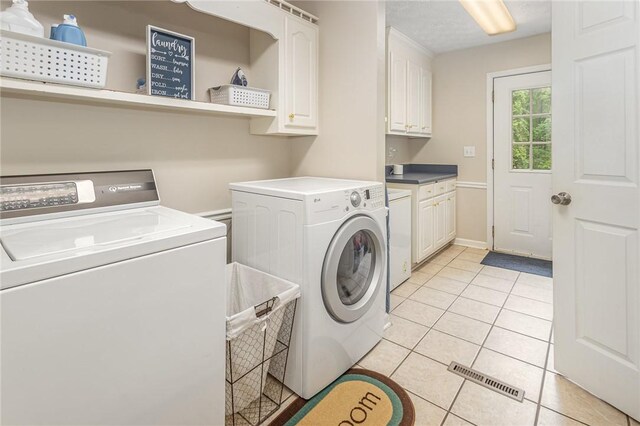 108 Ascot Ct, Easley, SC 29642 - laundry area with cabinet space, washing machine and clothes dryer, light tile patterned floors, and baseboards