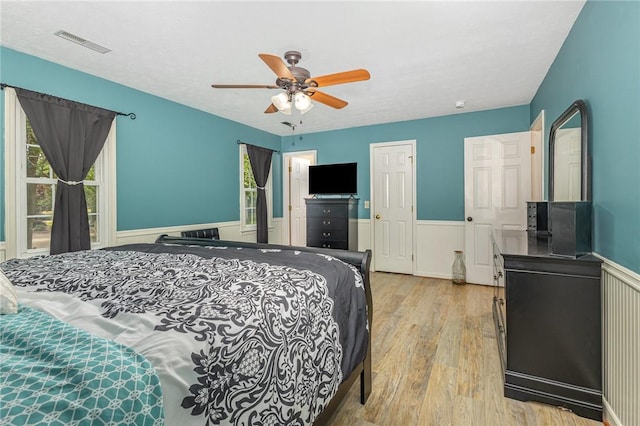 108 Ascot Ct, Easley, SC 29642 - bedroom featuring wood finished floors, wainscoting, multiple windows, and a ceiling fan