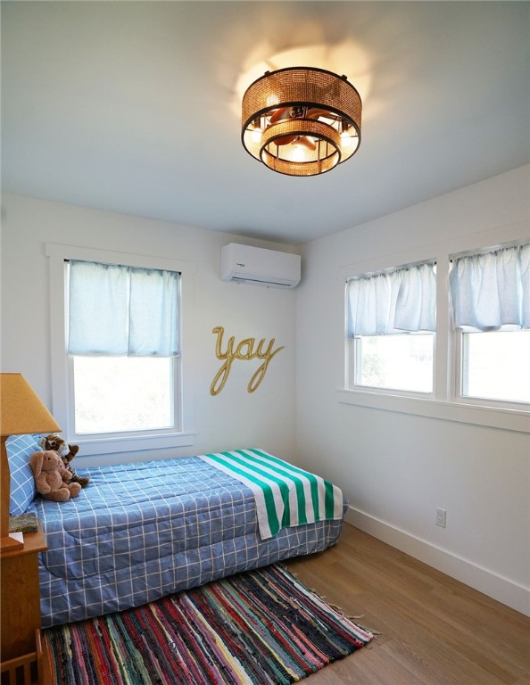 202 S Broad St, Westminster, SC 29693 - bedroom featuring a wall unit AC, wood finished floors, and baseboards