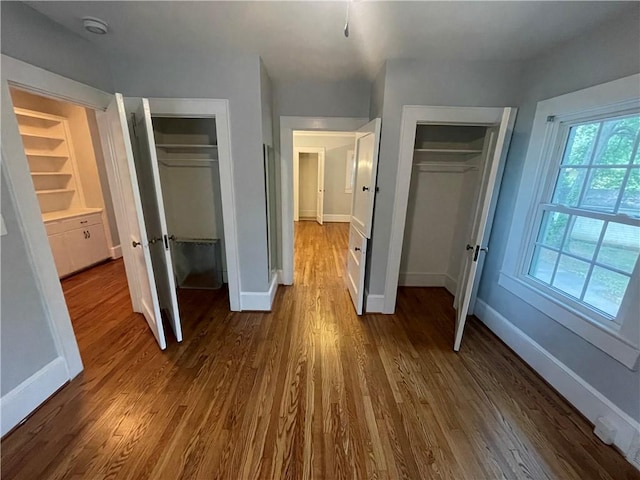 501 Seneca Dr, Seneca, SC 29678 - unfurnished bedroom with baseboards, dark wood-type flooring, and multiple closets
