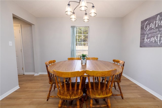 410 S Cove Rd, Seneca, SC 29672 - dining area with a chandelier, light wood finished floors, and baseboards