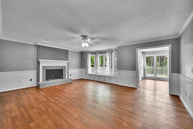 1208 Marett Rd, Pendleton, SC 29670 - unfurnished living room featuring a ceiling fan, wood finished floors, a wainscoted wall, a textured ceiling, and ornamental molding