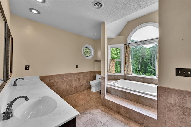 1208 Marett Rd, Pendleton, SC 29670 - full bath with a garden tub, toilet, double vanity, vaulted ceiling, and a textured ceiling