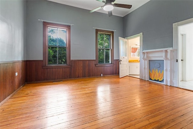 300 S Fairplay St, Seneca, SC 29678 - unfurnished living room featuring wainscoting, plenty of natural light, hardwood / wood-style flooring, a ceiling fan, and wood walls
