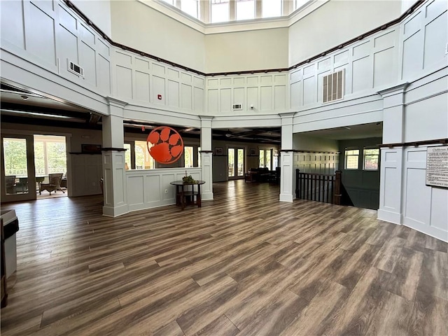 833 Old Greenville Hwy Unit 323, Clemson, SC 29631 - unfurnished living room featuring a towering ceiling, a decorative wall, and dark wood-style flooring
