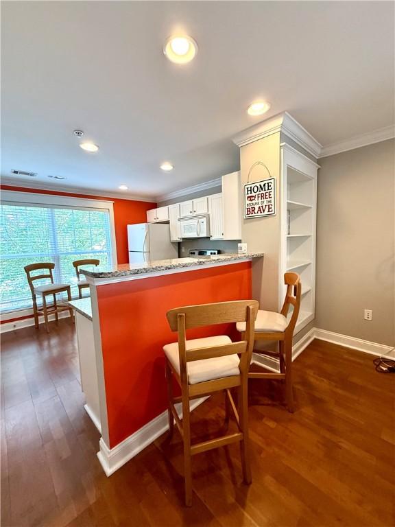 833 Old Greenville Hwy Unit 323, Clemson, SC 29631 - kitchen featuring white appliances, crown molding, light stone countertops, dark wood finished floors, and a peninsula