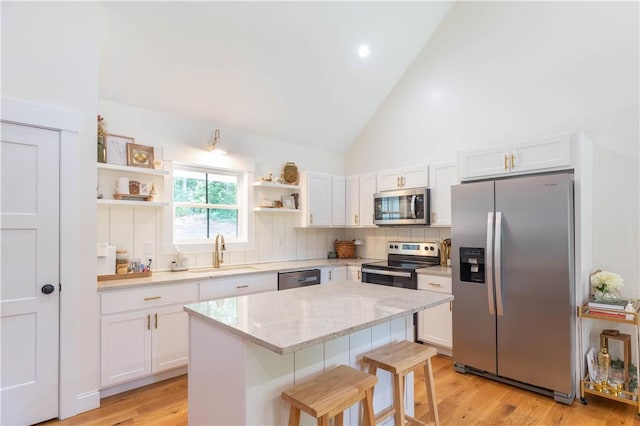 226 Edgewood Dr, Seneca, SC 29678 - kitchen featuring stainless steel appliances, a sink, open shelves, a kitchen bar, and white cabinetry