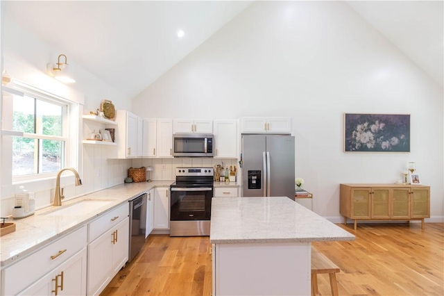 226 Edgewood Dr, Seneca, SC 29678 - kitchen featuring stainless steel appliances, a sink, high vaulted ceiling, a kitchen island, and white cabinetry