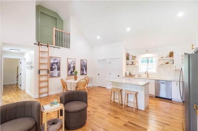 226 Edgewood Dr, Seneca, SC 29678 - kitchen with appliances with stainless steel finishes, open shelves, open floor plan, high vaulted ceiling, and a breakfast bar area