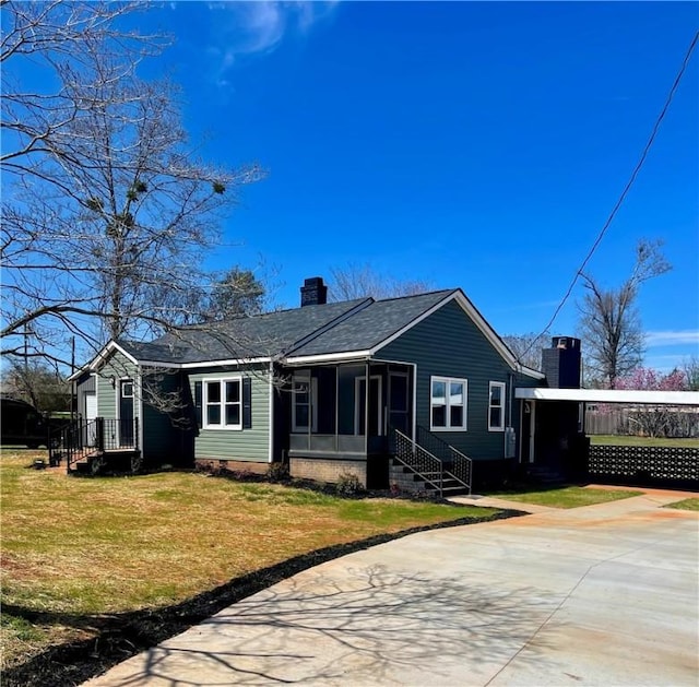 403 E S 5th St, Seneca, SC 29678 - ranch-style home featuring a chimney, concrete driveway, a sunroom, a front lawn, and an attached carport