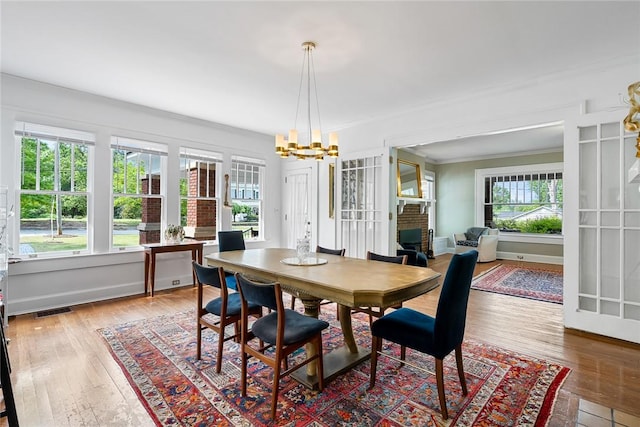 227 S Main St, Honea Path, SC 29654 - dining area with a chandelier, crown molding, hardwood / wood-style flooring, a fireplace, and baseboards