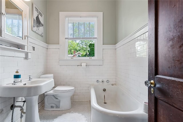 227 S Main St, Honea Path, SC 29654 - full bathroom with tile patterned flooring, a bath, toilet, tile walls, and a wainscoted wall