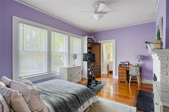 227 S Main St, Honea Path, SC 29654 - bedroom with multiple windows, light wood-style floors, ornamental molding, a brick fireplace, and ceiling fan