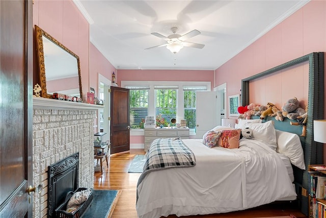 227 S Main St, Honea Path, SC 29654 - bedroom featuring ornamental molding, light wood-style flooring, a brick fireplace, and a ceiling fan