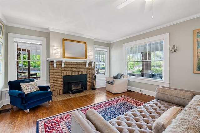 227 S Main St, Honea Path, SC 29654 - living room featuring wood finished floors, ornamental molding, a ceiling fan, baseboards, and a brick fireplace
