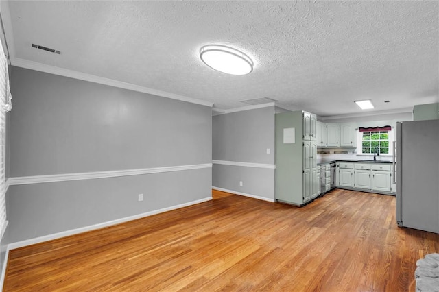 133 Cherokee Rd, Easley, SC 29642 - kitchen featuring freestanding refrigerator, light wood finished floors, a sink, a textured ceiling, and crown molding