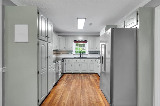 133 Cherokee Rd, Easley, SC 29642 - kitchen featuring appliances with stainless steel finishes, a sink, light wood finished floors, crown molding, and tasteful backsplash