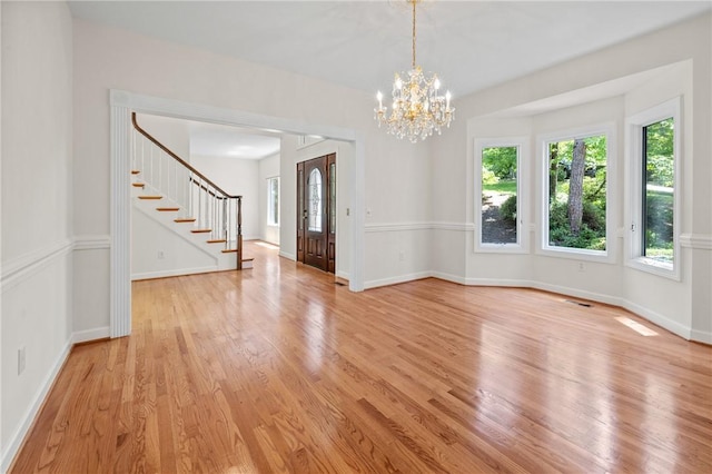 118 Pinnacle Pointe Dr, Seneca, SC 29672 - empty room with stairs, light wood finished floors, a chandelier, and baseboards