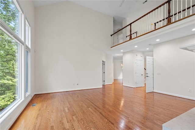 118 Pinnacle Pointe Dr, Seneca, SC 29672 - unfurnished living room featuring a high ceiling, light wood-style floors, and baseboards