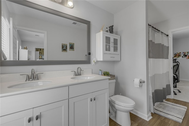 400 N Oak Crest Dr, Belton, SC 29627 - bathroom with wood finished floors, double vanity, toilet, baseboards, and a shower with shower curtain