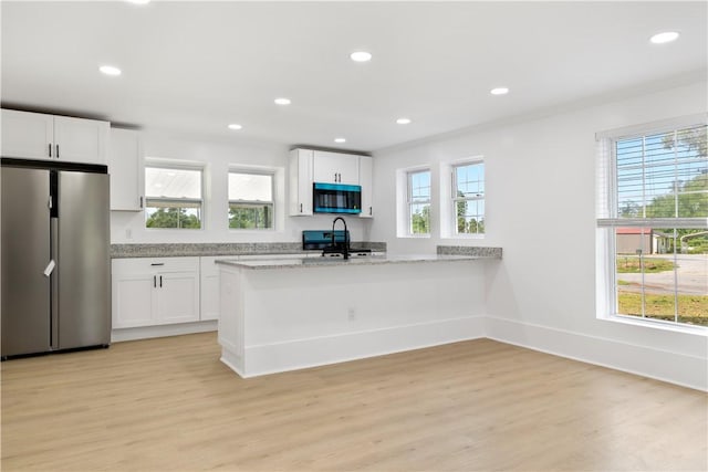 701 S Townville St, Seneca, SC 29678 - kitchen with freestanding refrigerator, range, white cabinetry, light stone countertops, and recessed lighting
