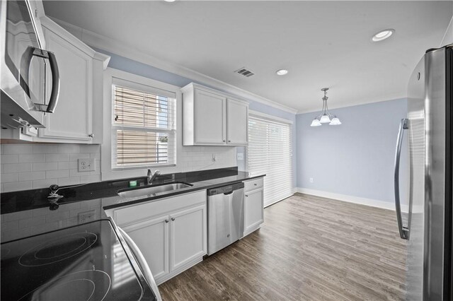 406 Bee Cove Way, Pendleton, SC 29670 - kitchen with appliances with stainless steel finishes, a sink, crown molding, dark countertops, and white cabinetry
