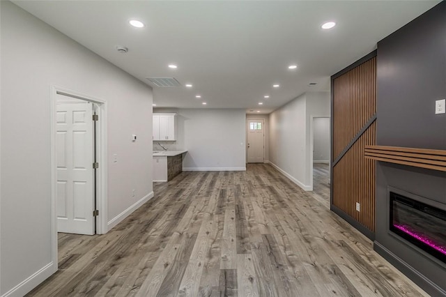 107A Avondale Rd, Anderson, SC 29624 - unfurnished living room featuring light wood-style floors, recessed lighting, baseboards, and a glass covered fireplace