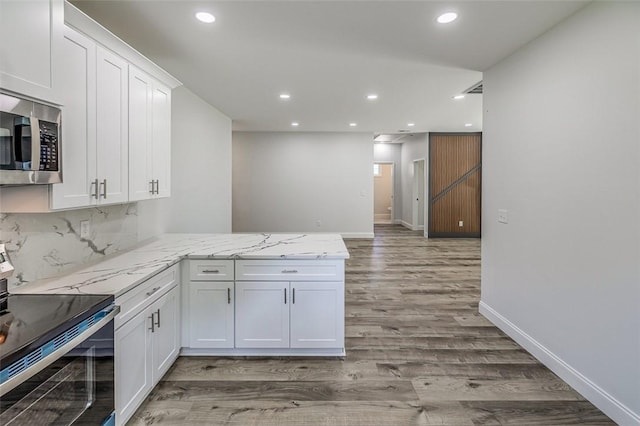 107A Avondale Rd, Anderson, SC 29624 - kitchen featuring stainless steel appliances, recessed lighting, white cabinets, wood finished floors, and a peninsula