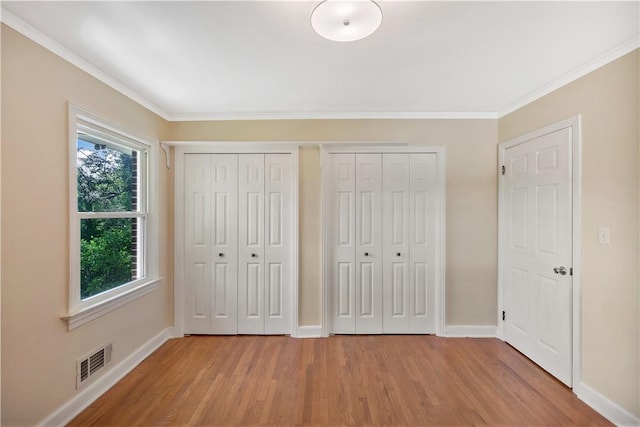 2400 Lane Ave, Anderson, SC 29621 - unfurnished bedroom featuring light wood-type flooring, two closets, ornamental molding, and baseboards