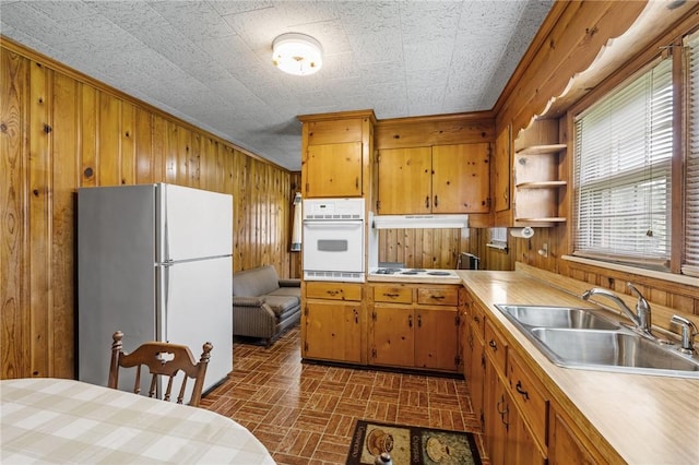 134 Grasshopper Hill Rd, Pickens, SC 29671 - kitchen with white appliances, wood walls, a sink, brick patterned flooring, and light countertops