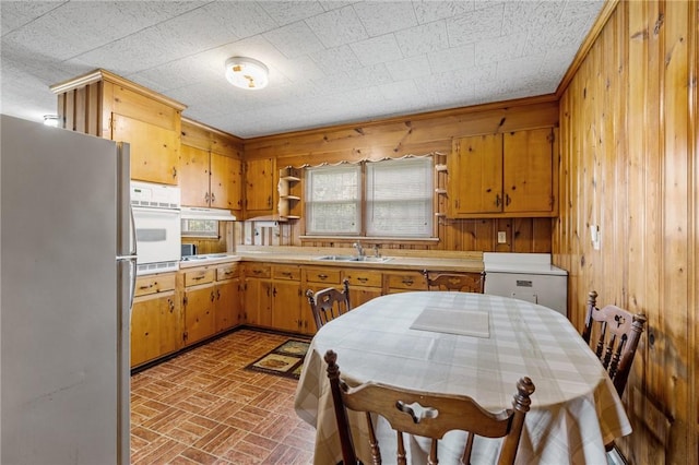 134 Grasshopper Hill Rd, Pickens, SC 29671 - kitchen featuring freestanding refrigerator, a sink, white oven, brick patterned flooring, and wooden walls