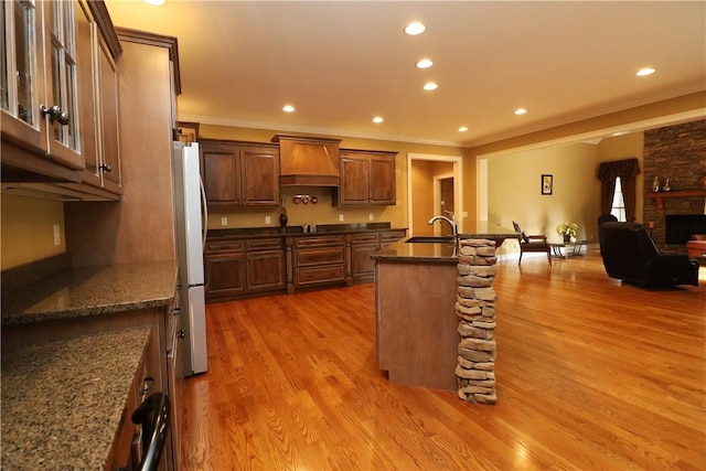 122 Langwell Dr, Anderson, SC 29621 - kitchen featuring premium range hood, freestanding refrigerator, a sink, open floor plan, and light wood finished floors