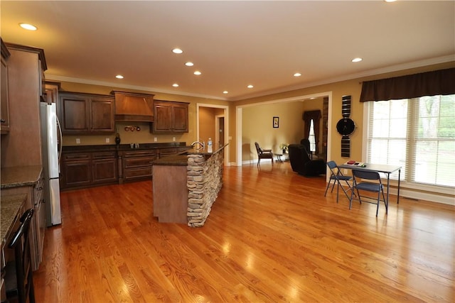 122 Langwell Dr, Anderson, SC 29621 - kitchen with freestanding refrigerator, custom range hood, ornamental molding, recessed lighting, and a kitchen island with sink