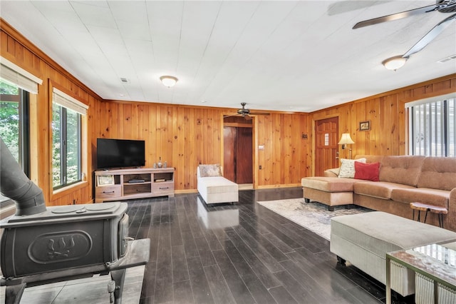 466 Whetstone Rd, Mountain Rest, SC 29664 - living room featuring a ceiling fan, a wood stove, wood walls, dark wood-style floors, and baseboards