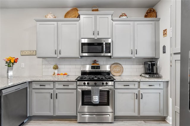 133 Shipyard Cir, Anderson, SC 29621 - kitchen with stainless steel appliances, tasteful backsplash, gray cabinets, and light stone counters
