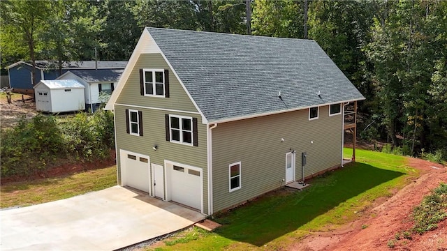 425 Lakewood Dr, Townville, SC 29689 - view of side of home featuring driveway, a yard, an attached garage, a shed, and roof with shingles