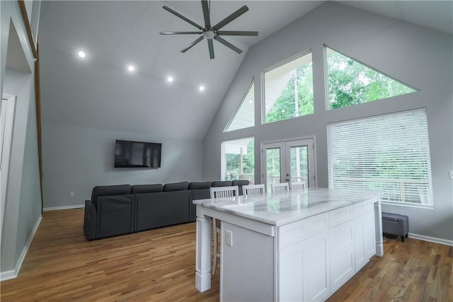 425 Lakewood Dr, Townville, SC 29689 - kitchen featuring white cabinets, a ceiling fan, a kitchen bar, french doors, and wood finished floors