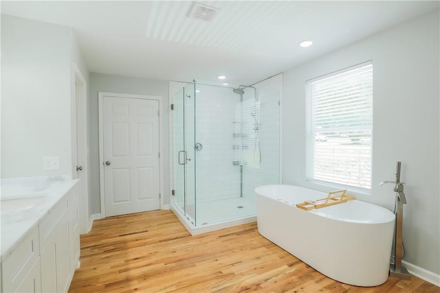 425 Lakewood Dr, Townville, SC 29689 - bathroom with a shower stall, a freestanding tub, wood finished floors, vanity, and recessed lighting