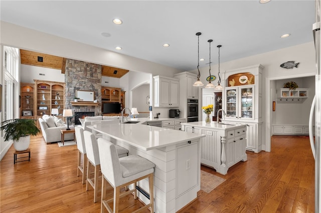 117 Misty Water Loop, Sunset, SC 29685 - kitchen featuring a sink, a center island with sink, a stone fireplace, recessed lighting, and a peninsula
