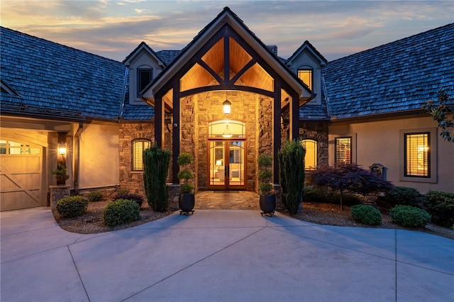 117 Misty Water Loop, Sunset, SC 29685 - exterior entry at dusk with stone siding, concrete driveway, and stucco siding