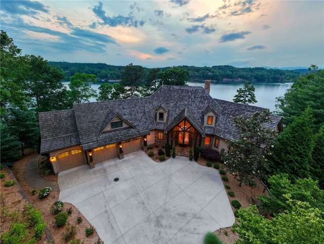 117 Misty Water Loop, Sunset, SC 29685 - view of front facade with a chimney, concrete driveway, an attached garage, a water view, and stone siding