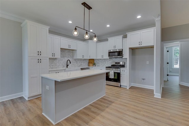 629 Mountain View Rd, Williamston, SC 29697 - kitchen featuring stainless steel appliances, white cabinets, light wood-type flooring, tasteful backsplash, and a kitchen island