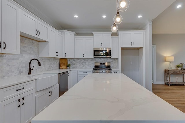 629 Mountain View Rd, Williamston, SC 29697 - kitchen featuring appliances with stainless steel finishes, a kitchen island, white cabinetry, backsplash, and light wood-style flooring